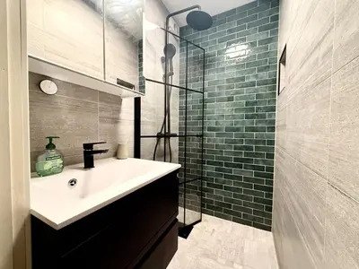 a bathroom with a sink and a glass shower at Rustic Retreat Apartment, Central & free parking ! in Trondheim
