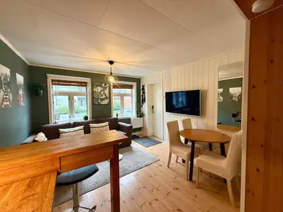 a living room with a couch and a table at Rustic Retreat Apartment, Central & free parking ! in Trondheim