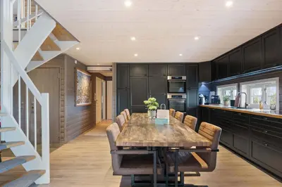 a dining room with a table and a kitchen at Mosetra2038 by Vacationtrysil in Trysil