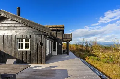 a wooden cabin with a boardwalk in front of it at Mosetra2038 by Vacationtrysil in Trysil