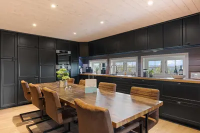 a large kitchen with a wooden table and chairs at Mosetra2038 by Vacationtrysil in Trysil