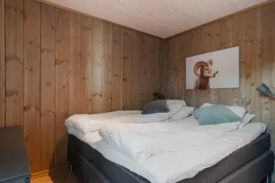 a large bed in a room with wooden walls at Mosetra2038 by Vacationtrysil in Trysil