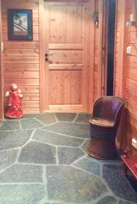 a room with a chair and a door and a teddy bear at Cabin By Trillemarka Nature Reserve in Eiddal