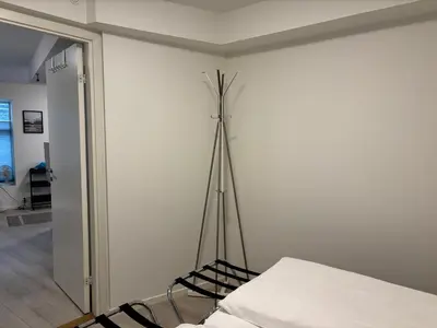 a white room with a bed and a tripod at Modern Apt - Steps from Grieghallen and Trainstation in Bergen