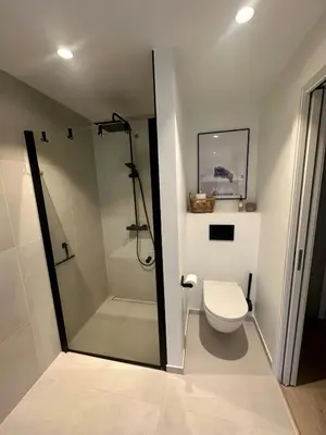 a bathroom with a shower and a toilet in it at Spacious, central 3 BR house with parking in Bergen