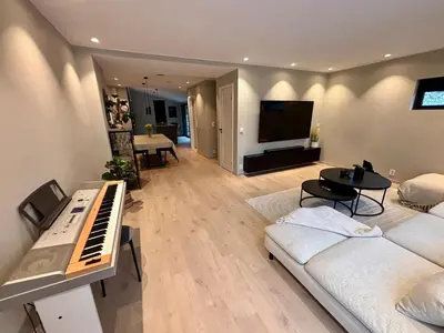 a living room with a piano and a television at Spacious, central 3 BR house with parking in Bergen