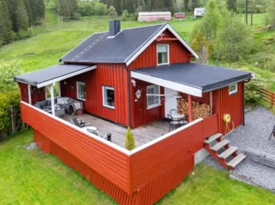 a red house with a large deck at Kvila in Tingvoll