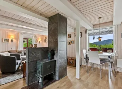 a living room with a fireplace and a dining room at Kvila in Tingvoll