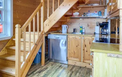 a kitchen with a staircase in a log cabin at Gorgeous Home In Leinøy With House Sea View in Fosnavåg