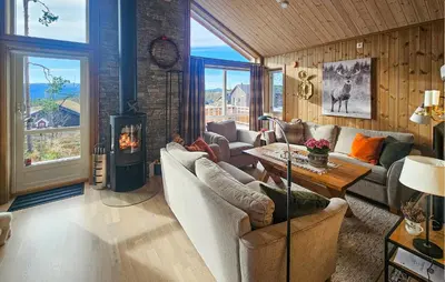 a living room with couches and a wood stove at 3 Bedroom Lovely Home In Flå in Flå