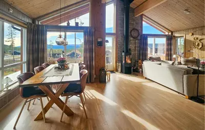 a dining room with a table and a living room at 3 Bedroom Lovely Home In Flå in Flå