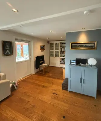 a living room with a blue cabinet and wooden floors at Modern Cabin With Panoramic Views In Aukland in Jelsa