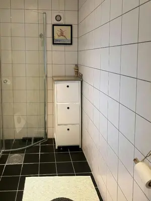 a bathroom with a small refrigerator and a tile wall at Modern Cabin With Panoramic Views In Aukland in Jelsa