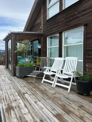 two white chairs sitting on a wooden deck at Modern Cabin With Panoramic Views In Aukland in Jelsa