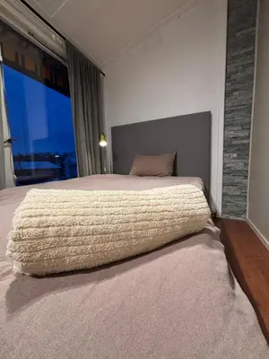 a bedroom with a large bed with a large window at Koselig rom i studentfelleskap