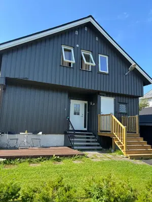a black house with a porch and a deck at Koselig rom i studentfelleskap