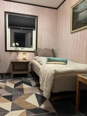 a bedroom with a bed and a window and a table at Koselig rom i studentfelleskap