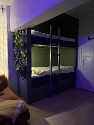 a bedroom with two bunk beds with purple lighting at Askvik Marina Lägenhet i småbåtshamn med havsutsikt