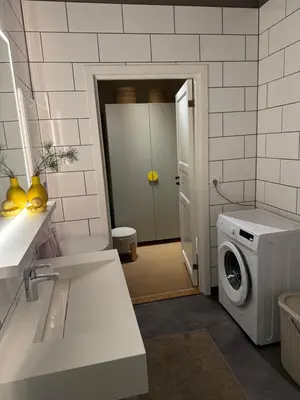 a kitchen with a washing machine and a washer at Askvik Marina Lägenhet i småbåtshamn med havsutsikt