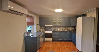 a kitchen with blue cabinets and a white refrigerator at Comfortable apartment near the city center and nature