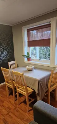 a dining room with a table and chairs and a window at Comfortable apartment near the city center and nature