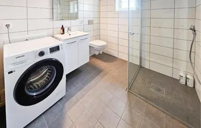 a white washing machine in a bathroom with a toilet at Stunning Home In Torpo With Wifi in Torpo