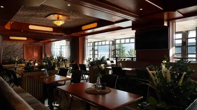 a restaurant with tables and chairs and windows at Vestnes Fjordhotell in Vestnes