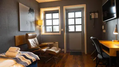 a bedroom with a bed and a desk and chairs at Vestnes Fjordhotell in Vestnes
