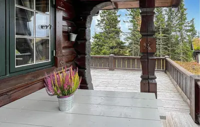 a vase of flowers sitting on the porch of a house at Lovely Home In Sjusjøen With Sauna in Sjusjøen