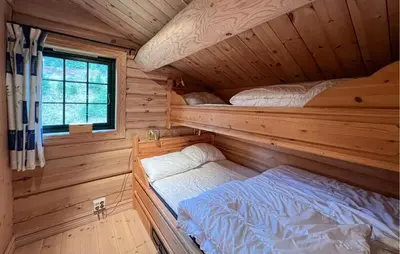 a bedroom with two bunk beds in a log cabin at Lovely Home In Sjusjøen With Sauna in Sjusjøen