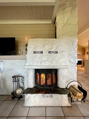 a stone fireplace in a living room with a tv at Spacious cabin in Hemsedal with sauna, near slopes in Hemsedal