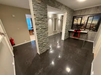 an empty living room with a stone wall at Kristiansund Luxury Apartment in Kristiansund
