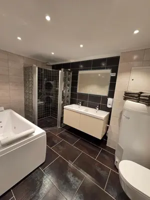 a bathroom with a tub and a sink and a toilet at Kristiansund Luxury Apartment in Kristiansund