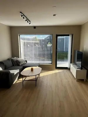 a living room with a couch and a table and a tv at Newly refurbished apartment in the city center in Verdal