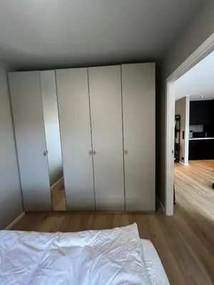 a bedroom with white cabinets and a bed at Newly refurbished apartment in the city center in Verdal