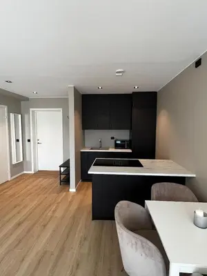 a kitchen with black cabinets and a white counter top at Newly refurbished apartment in the city center in Verdal