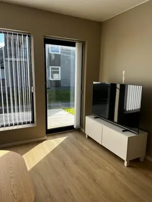 a living room with a flat screen tv on a white cabinet at Newly refurbished apartment in the city center in Verdal