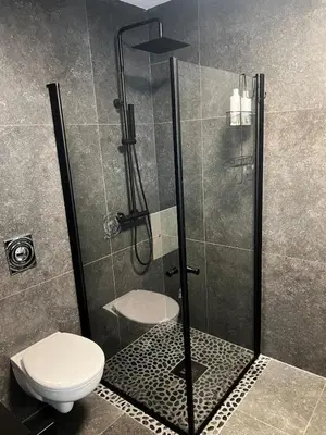 a shower stall with a toilet in a bathroom at Newly refurbished apartment in the city center in Verdal