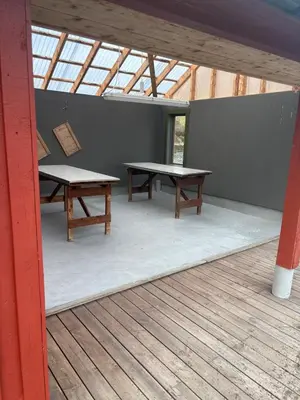 two picnic tables in a building with windows at Strand huset in Hitra