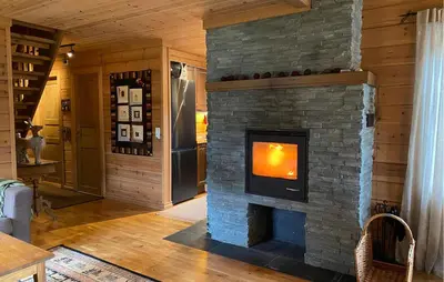 a living room with a stone fireplace in a house at Gorgeous Home In Bjorli With Wifi in Bjorli