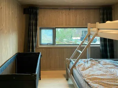 a small bedroom with a bunk bed and a window at Modern Family Cabin By The Ski Trail In Tuddal in Tuddal