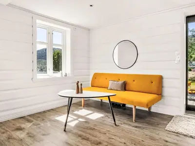 a yellow couch in a room with a table at Holiday Home Holmen by Interhome in Strandebarm