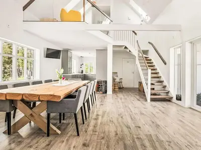 a kitchen and dining room with a wooden table and chairs at Holiday Home Holmen by Interhome in Strandebarm