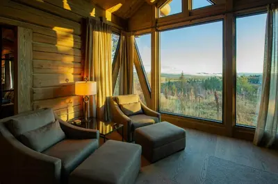 a living room with two chairs and a large window at Handcrafted Log Cabin At Golsfjellet in Gol