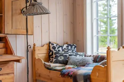 a room with a bed with pillows and a lamp at Fagerasen 303 by Vacation Trysil in Trysil
