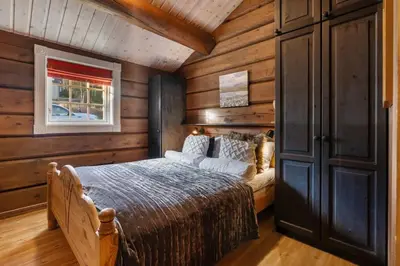a bedroom with a bed in a room with wooden walls at Trysilfjell 615 by Vacation Trysil in Trysil