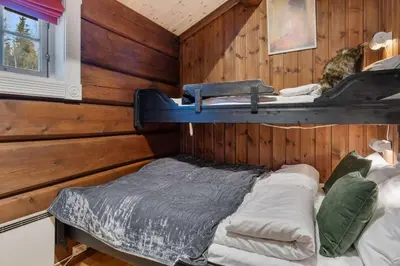 a bedroom with a wooden wall with a bed in it at Trysilfjell 615 by Vacation Trysil in Trysil