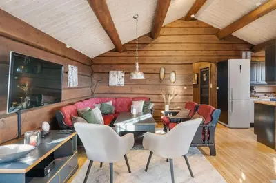 a living room with a red couch and white chairs at Trysilfjell 615 by Vacation Trysil in Trysil