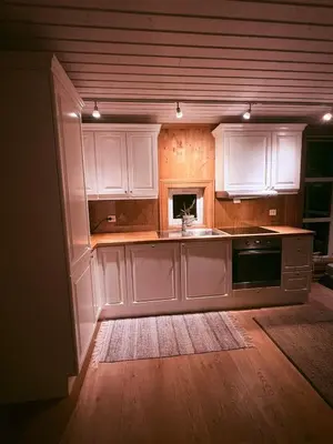 a kitchen with white cabinets and a sink at Nikolaisens Nordic Panorama hideaway in Stranda