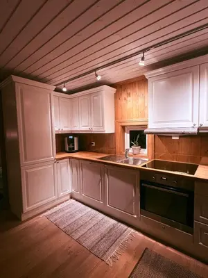 a kitchen with white cabinets and a sink at Nikolaisens Nordic Panorama hideaway in Stranda